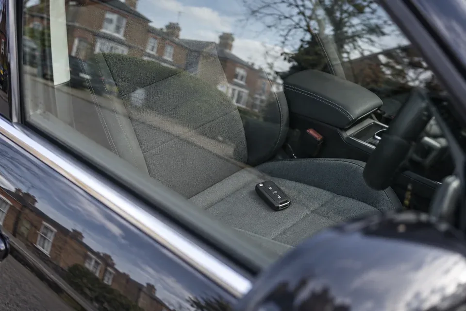 Car keys visible on the seat through a closed car window