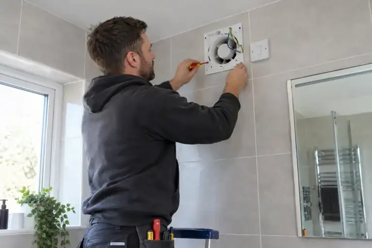 Extractor fan installation: a professional electrician assessing or carrying out the electrical work.