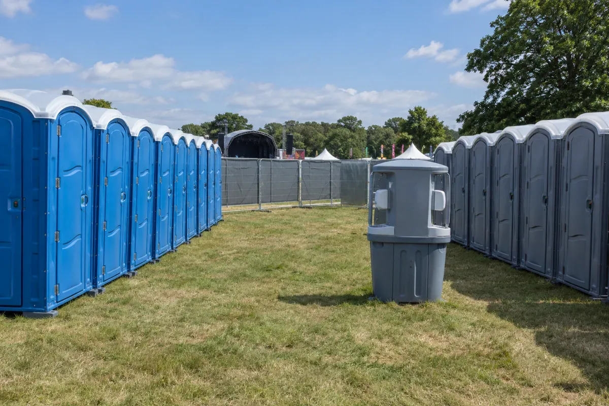 Illustration of festival toilet banks with a hand-wash point and distant stage